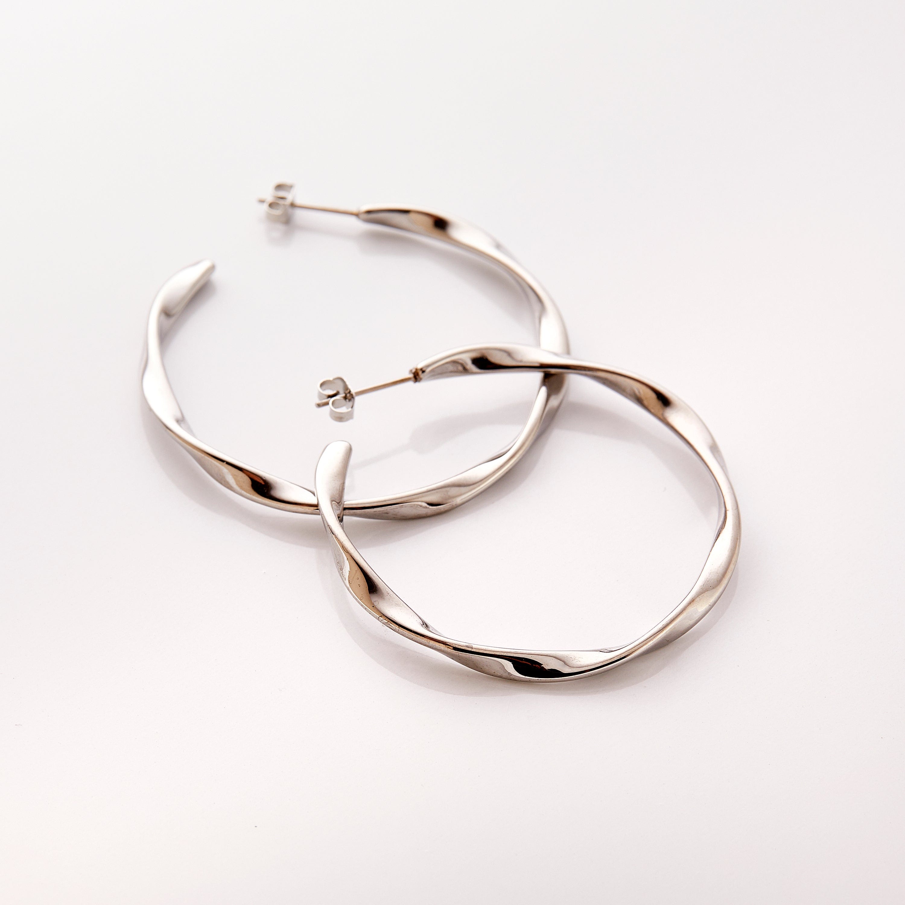 The silver Ripple Hoop Earrings against a white background.