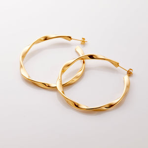 The gold Ripple Hoop Earrings against a white background.