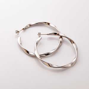 The silver Ripple Hoop Earrings against a white background.