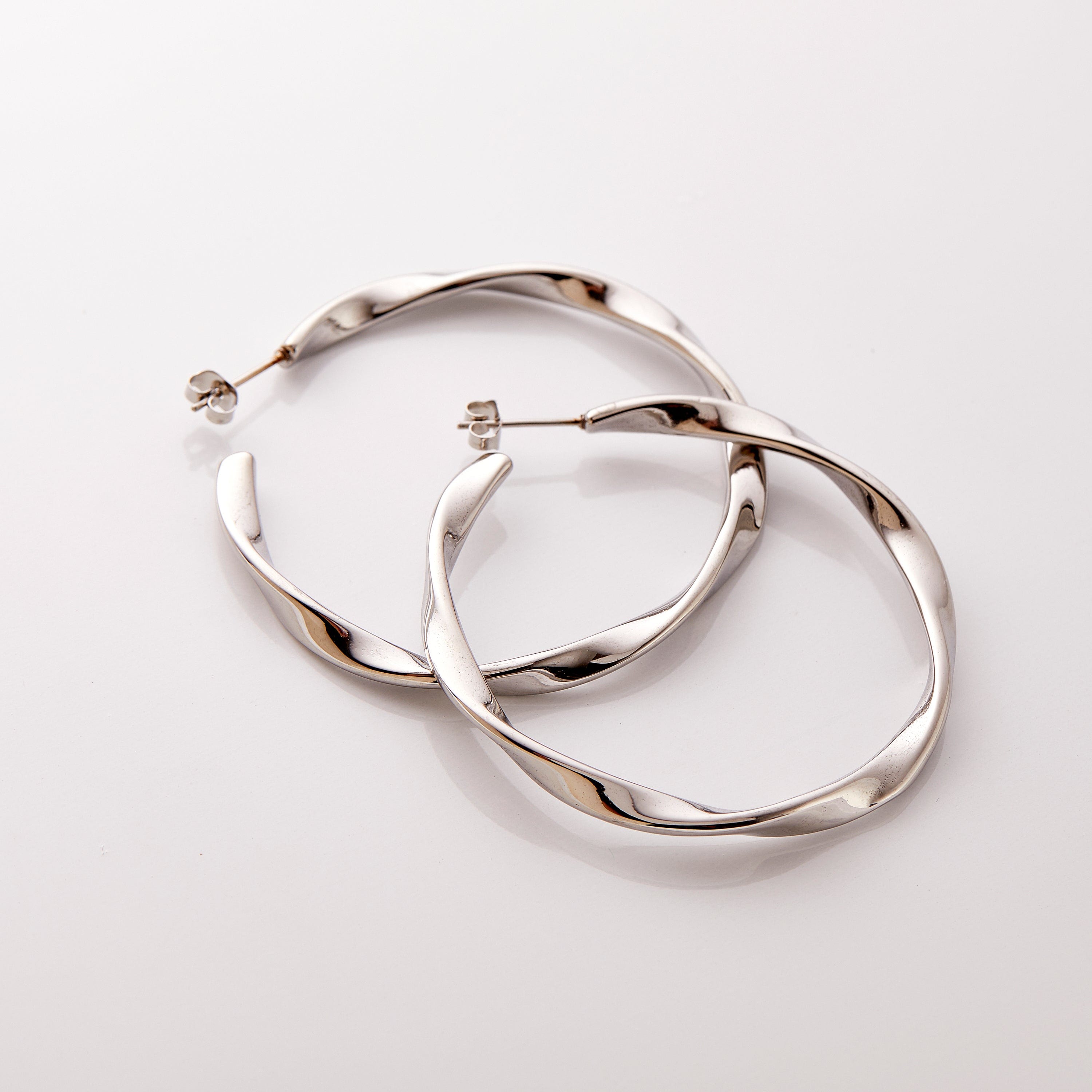 The silver Ripple Hoop Earrings against a white background.