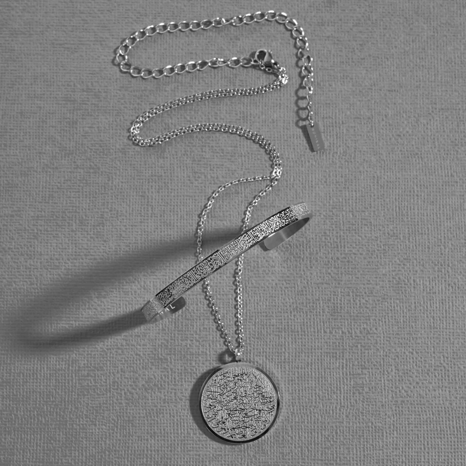 Photo of the silver Ayatul Kursi necklace and Ayatul Kursi Cuff.