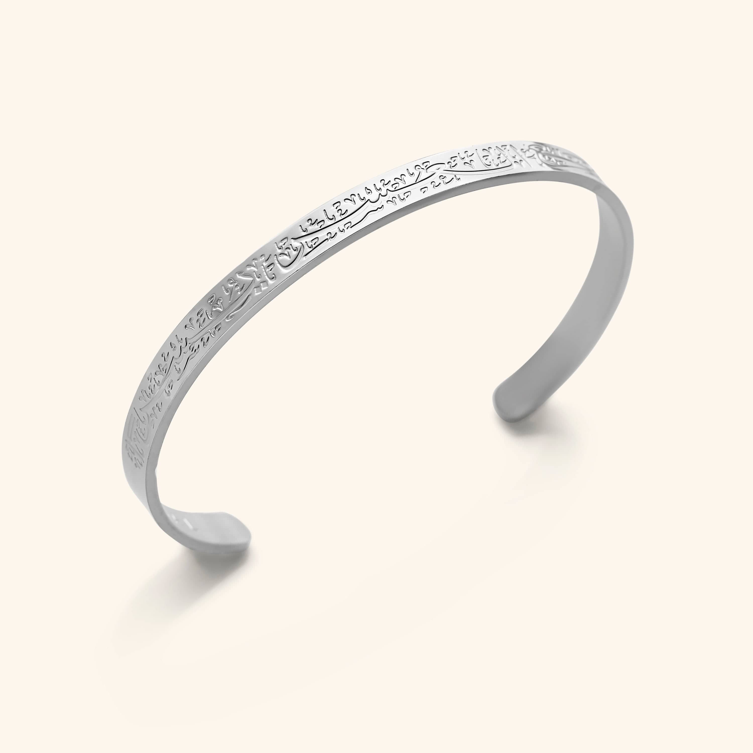 The "With Hardship Comes Ease" Cuff V2 in a polished silver finish. The cuff displays the same embossed Arabic calligraphy inscription as the gold version, offering a sleek and timeless design.
