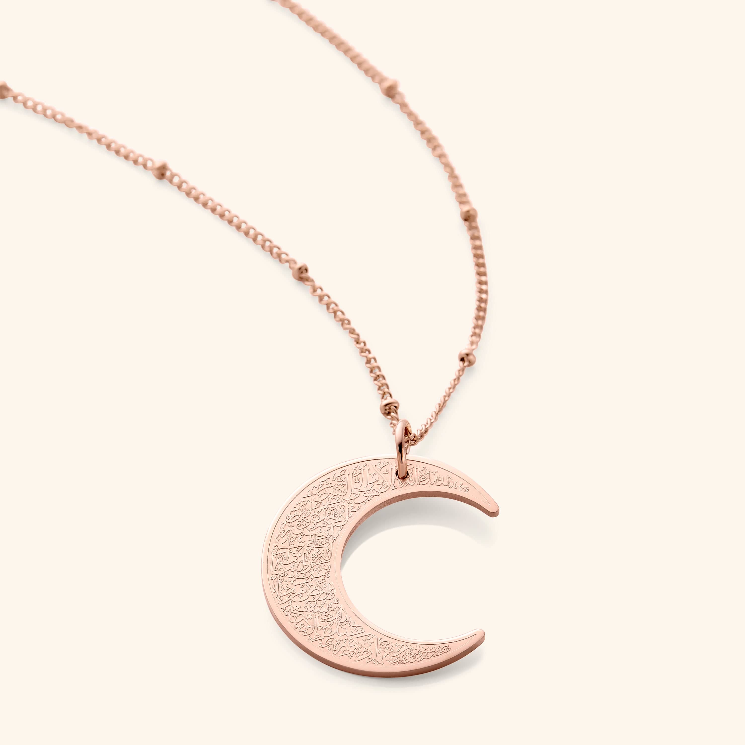 A rose gold rendition of the Ayatul Kursi Crescent Necklace, highlighting the crescent-shaped pendant with ornate Arabic calligraphy, attached to a matching rose gold chain.