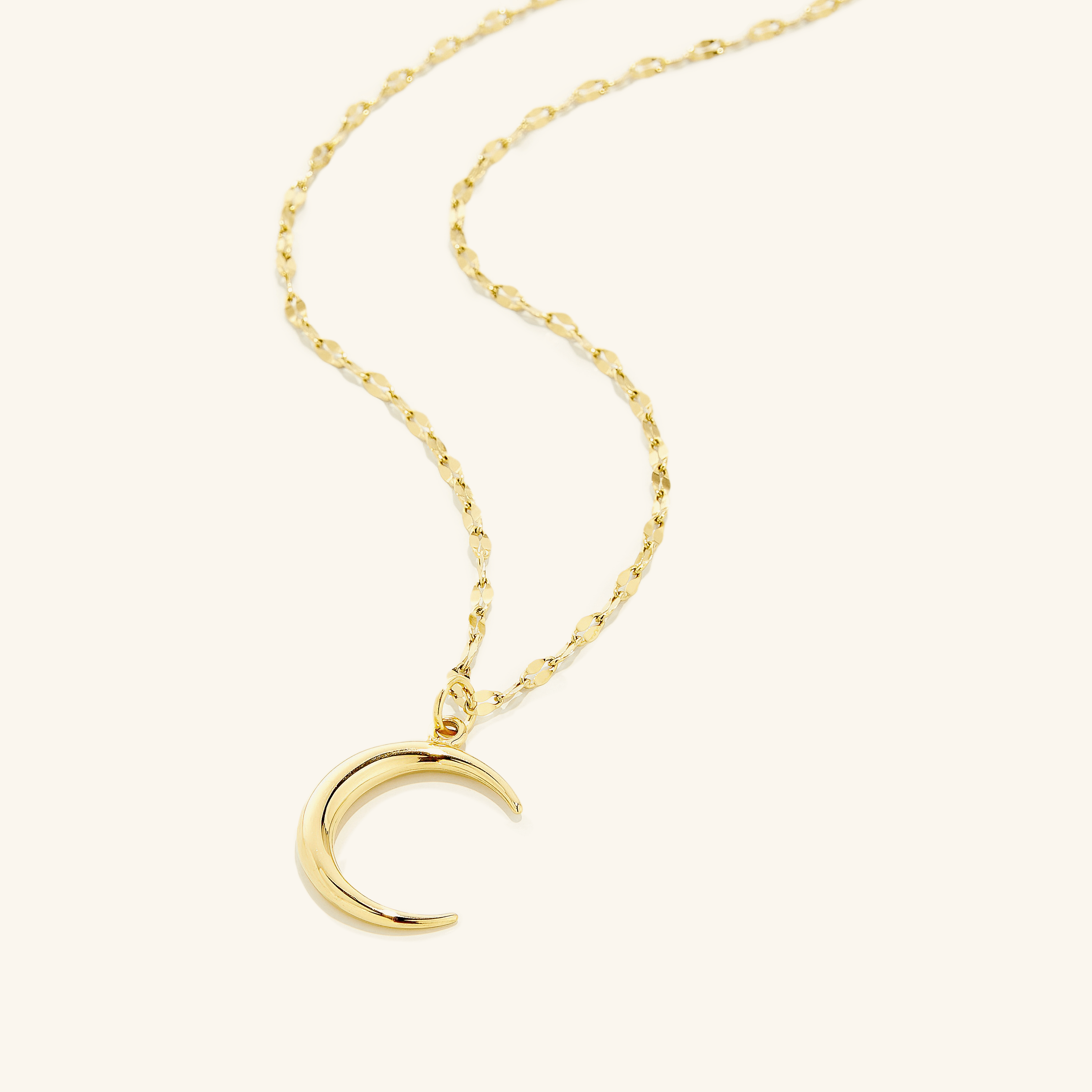 Flat lay of the 18k gold plated  Premium Crescent that offers a unique design that stays true to the sentiment of the classic predecessor, but with an elegantly softer 3D mold and a brand new chain 