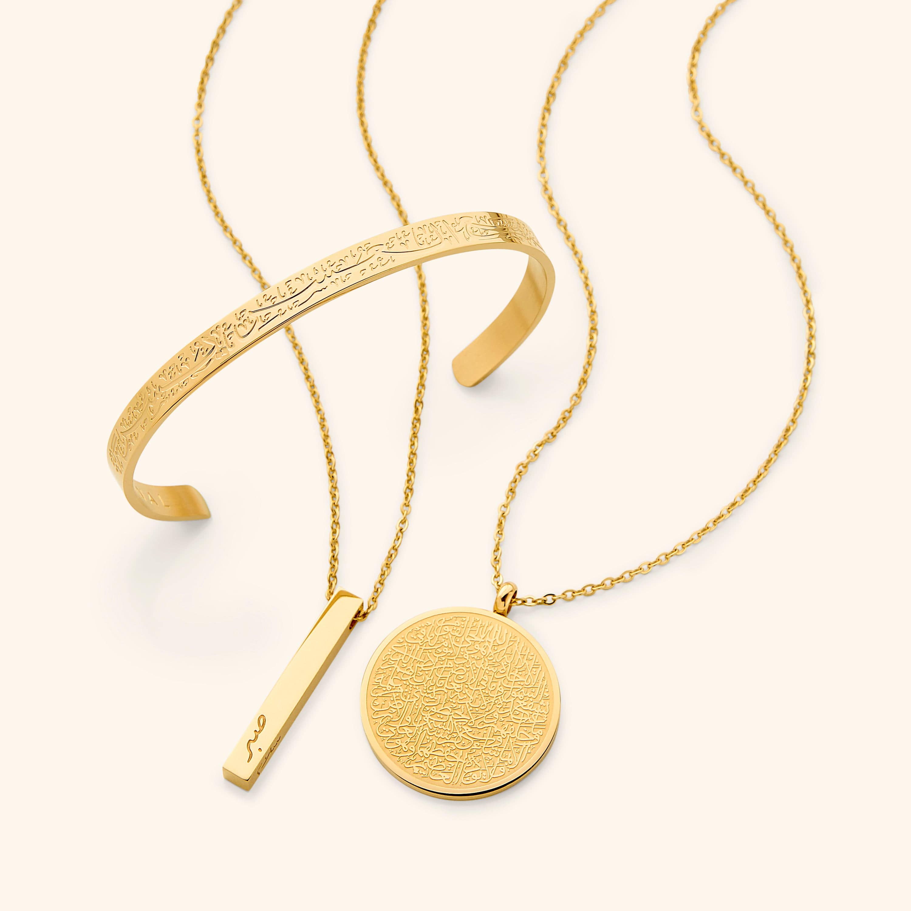 In the photo: Ayatul Kursi Necklace, Mini Core Values Bar Necklace, and "With Hardship Comes Ease" V2 Cuff all in gold.