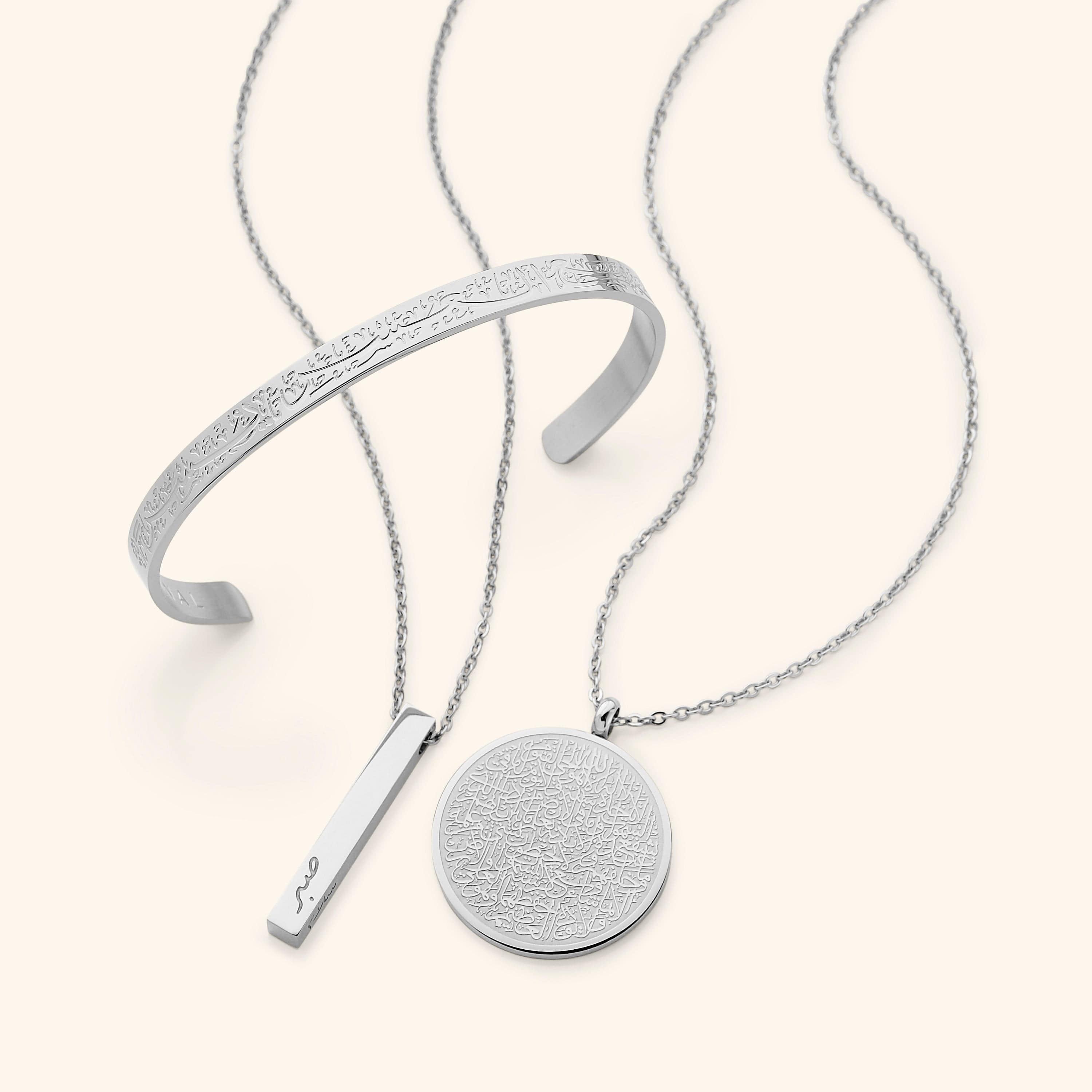 In the photo: Ayatul Kursi Necklace, Mini Core Values Bar Necklace, and "With Hardship Comes Ease" V2 Cuff all in silver