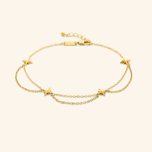 An 18k gold plated anklet that features north stars all along the chain, drooping chains connecting each one design.