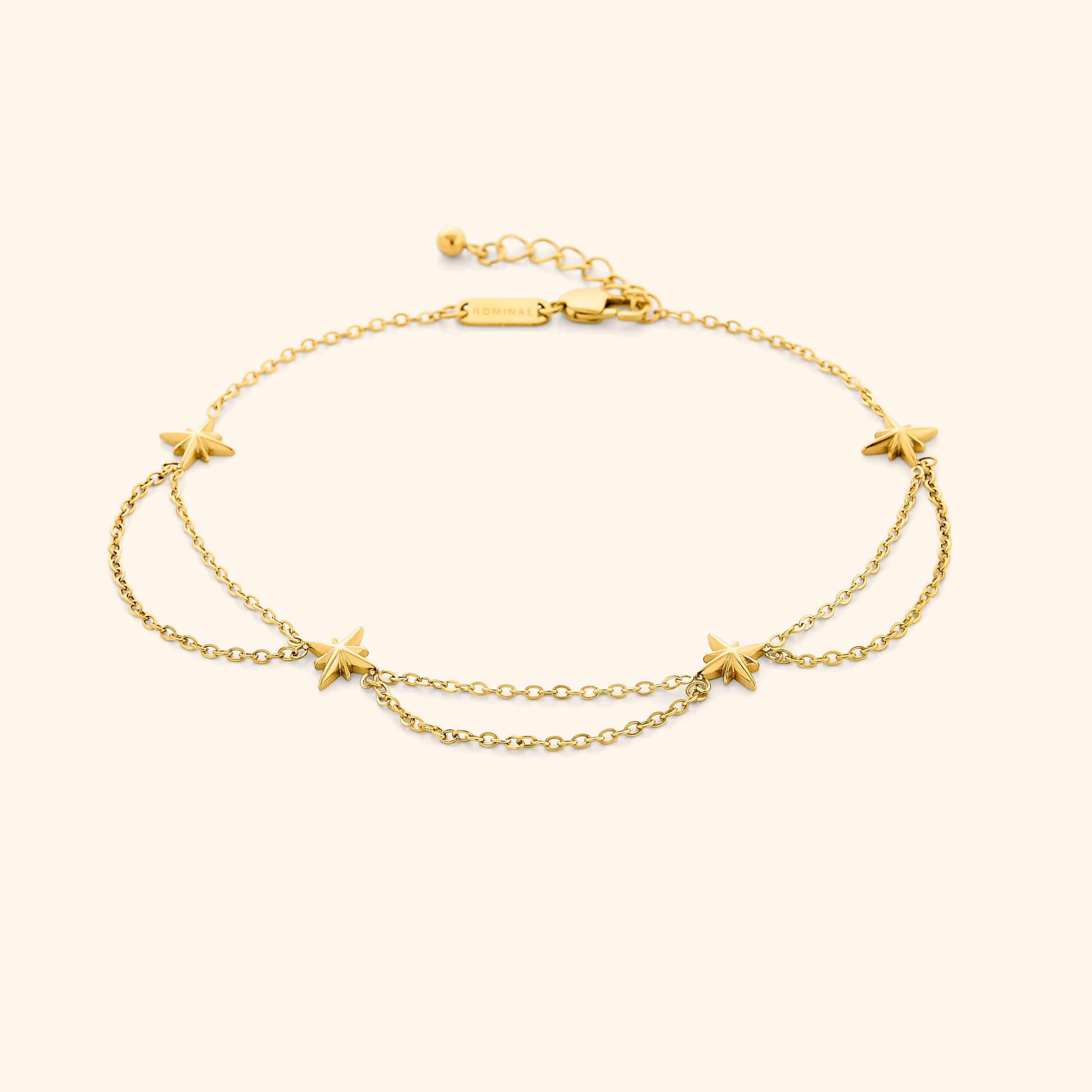An 18k gold plated anklet that features north stars all along the chain, drooping chains connecting each one design.