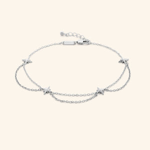A silver anklet that features north stars all along the chain, drooping chains connecting each one design.