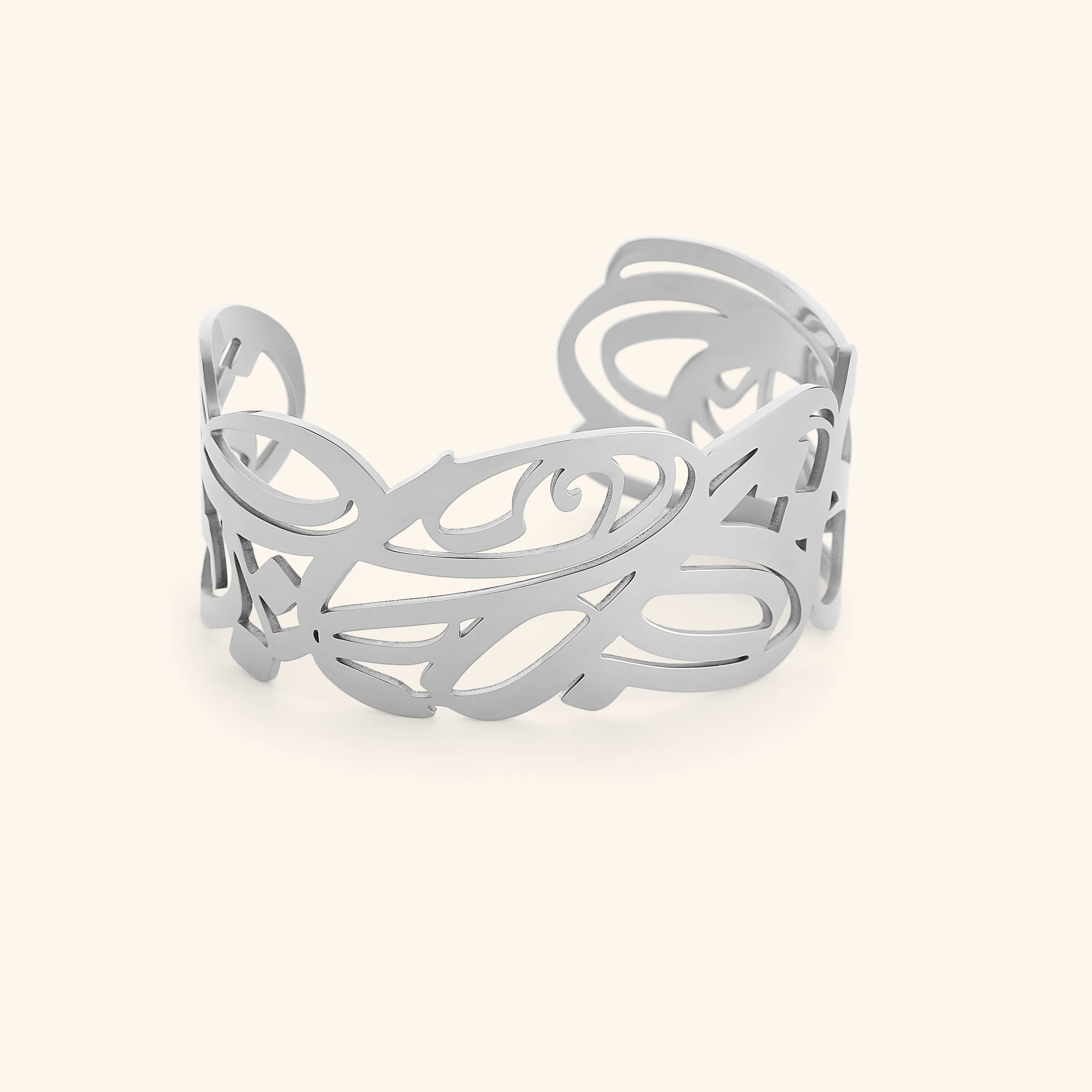 A silver cuff bracelet with intricate, swirling cut-out designs. The bracelet is wide and open-ended, and the delicate patterns create a lacy or filigree effect. The text "GRACE (Cuff) | Aadil x Nominal" indicates this is a product shot of the "Grace" cuff bracelet, a collaboration between Aadil and Nominal.