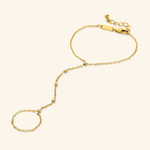 Close-up of the Diamond Path Hand Chain in 18K gold plating, showing the delicate chain adorned with five bezel-set 3mm cubic zirconia stones, designed to connect a ring to the wrist.