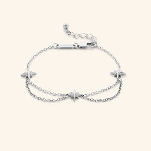 A silver bracelet that features north stars all along the chain, drooping chains connecting each one design.