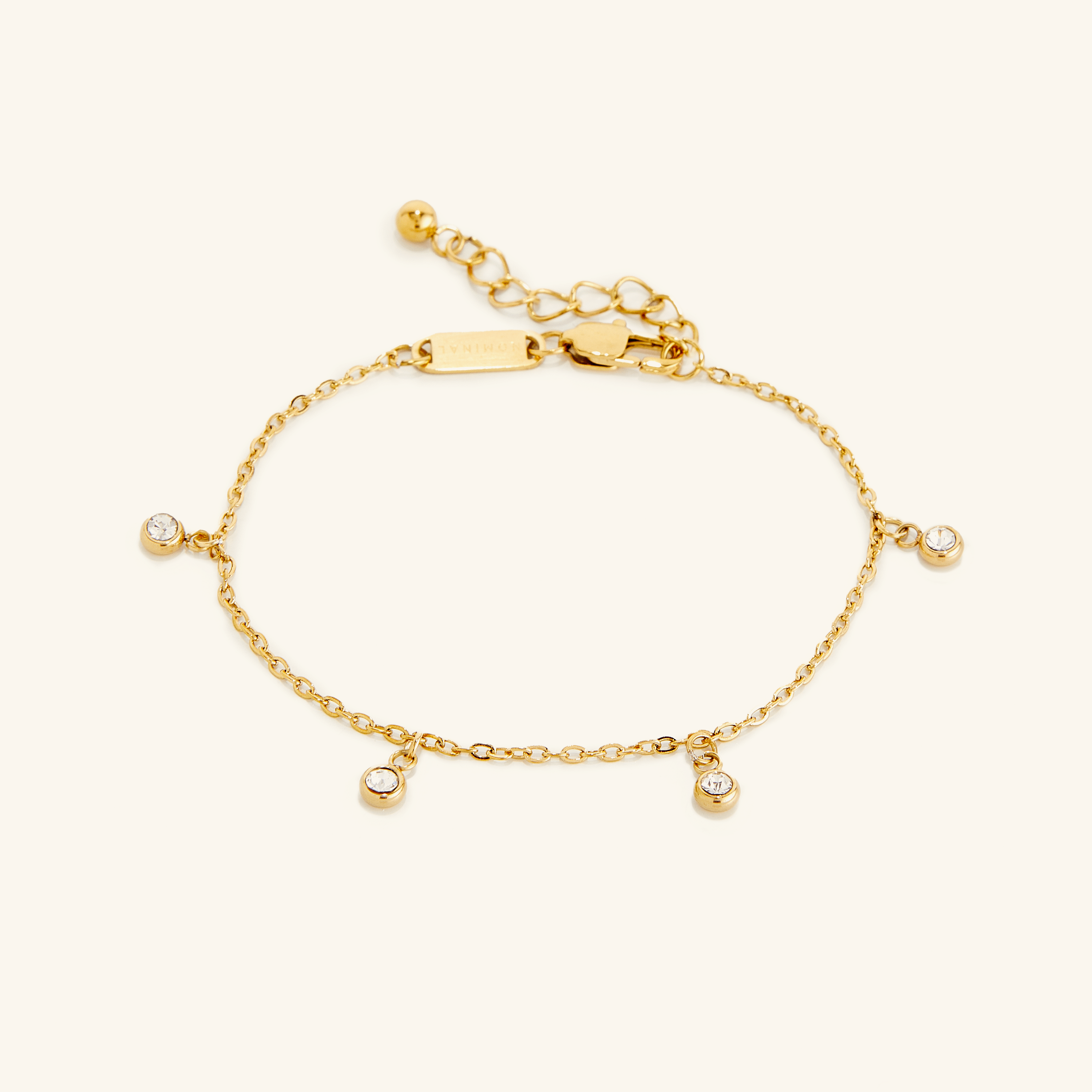 Flat lay of the gold Raining Bezel Bracelet on a light background.