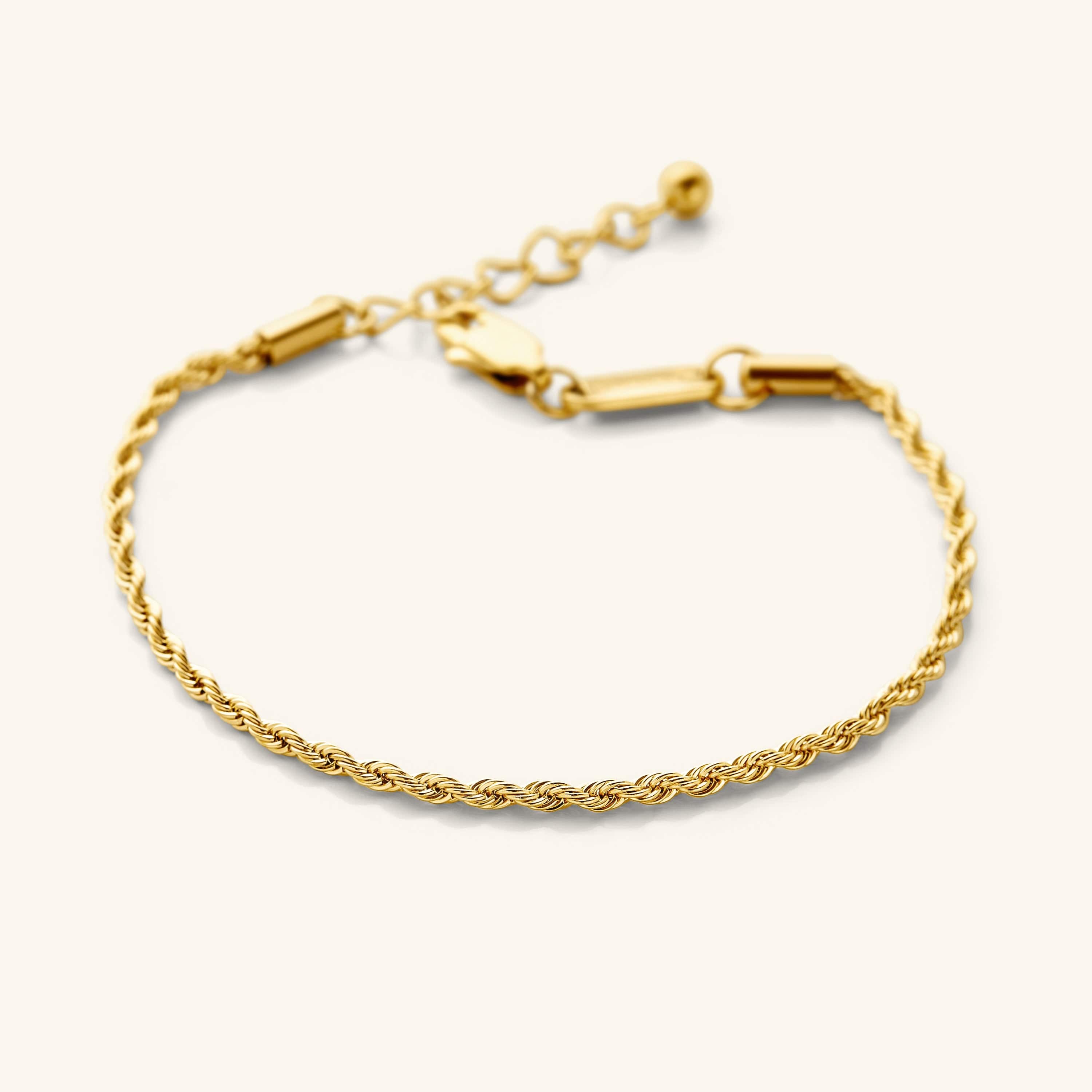 Flat lay of the 18k gold plated essential rope bracelet that features a woven chain pattern.