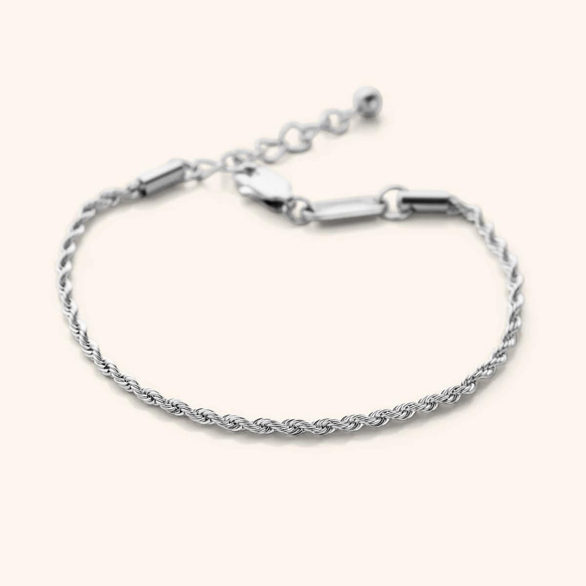 Flat lay of the silver essential rope bracelet that features a woven chain pattern.