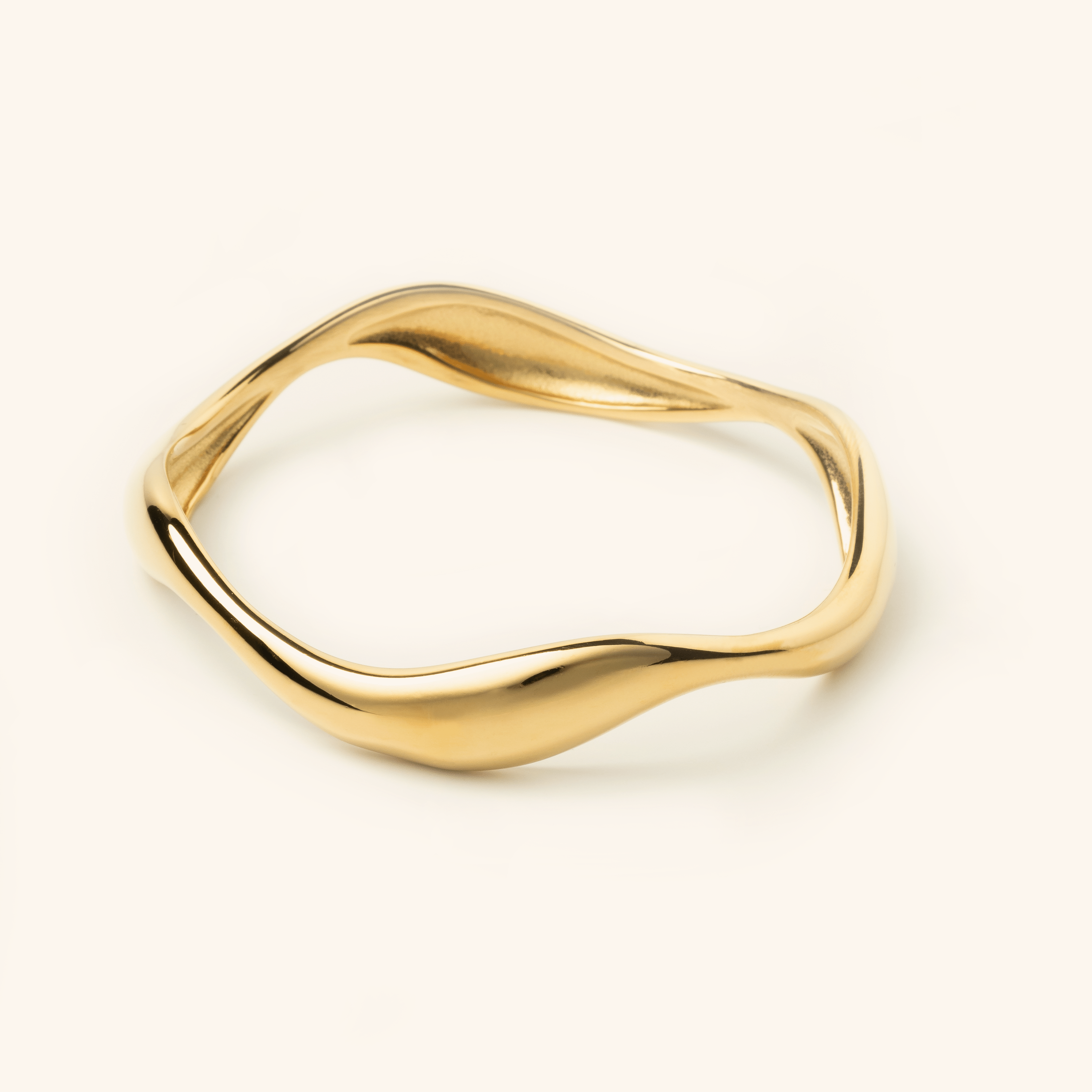 Photo of an 18k gold plated Wave Bangle features cascading curves to remind you that life ebbs and flows.