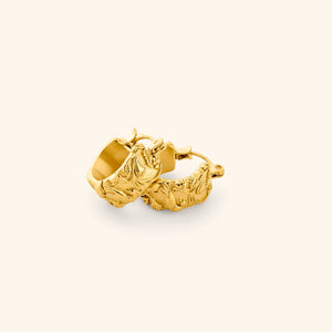 A pair of 18k gold thick hoop earrings wrapped in jasmine, marigolds, and water lilies across the entire surface