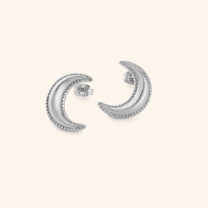 Silver crescent moon earrings with dotted design, shot on a white background