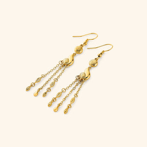  A pair of 18k gold plated earrings that features paisley droplets suspended from textured coins, each one trailing three delicate chains that move when you do.