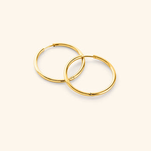 Flat lay of the 18k gold plated Large Essential Hoops | 25mm against a white background.
