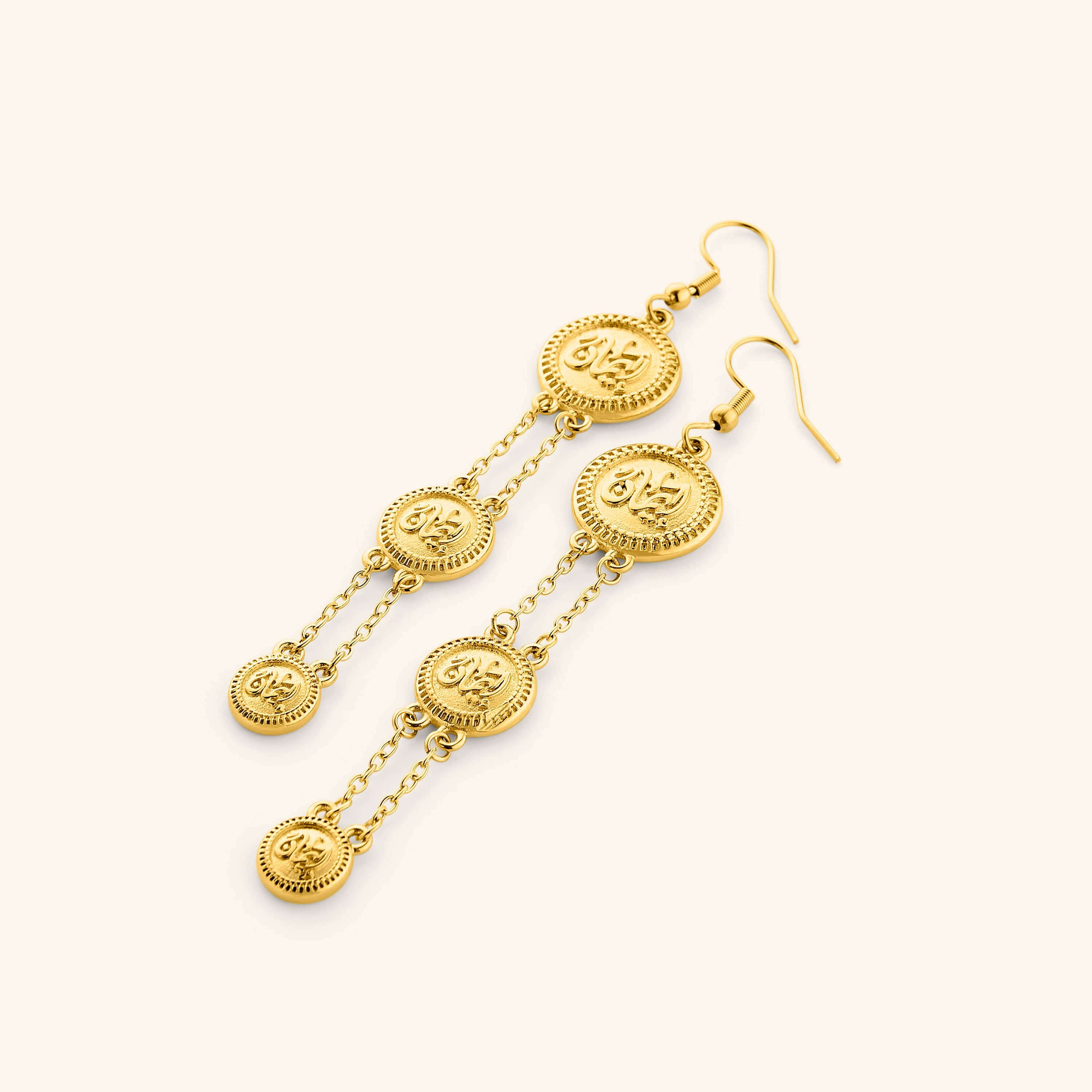A pair of tri-coin 18k gold plated earrings  embossed with Arabic calligraphy "Iman". The coins drape from each other with a gold double-chain.