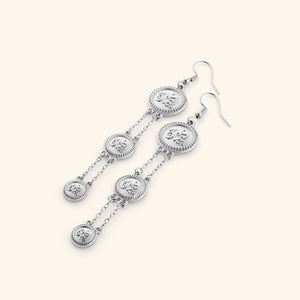 A pair of tri-coin silver earrings  embossed with Arabic calligraphy "Iman". The coins drape from each other with a silver double-chain.