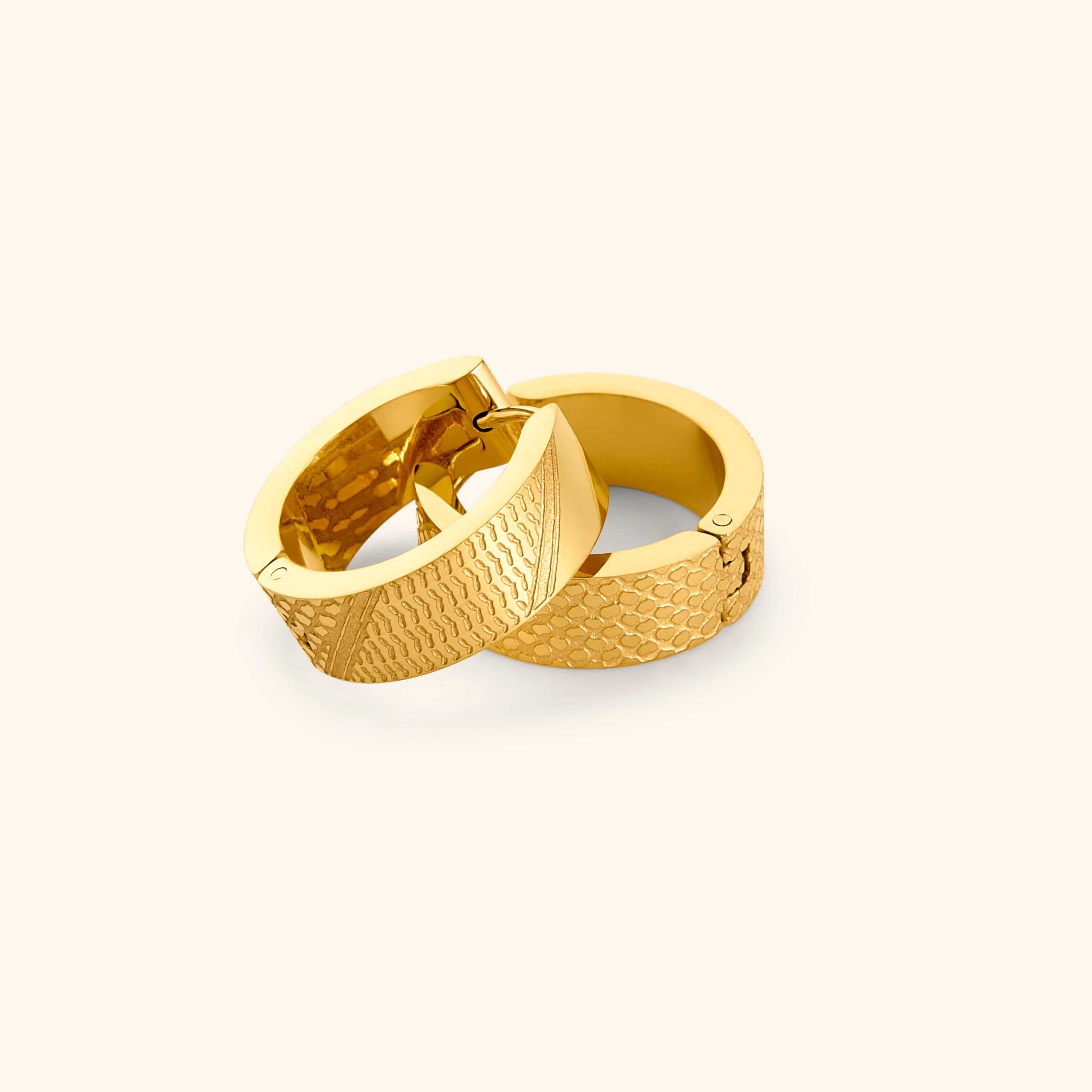 Pair of gold keffiyeh chunky hoops on a light background