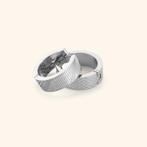 Pair of silver keffiyeh chunky hoops on a light background