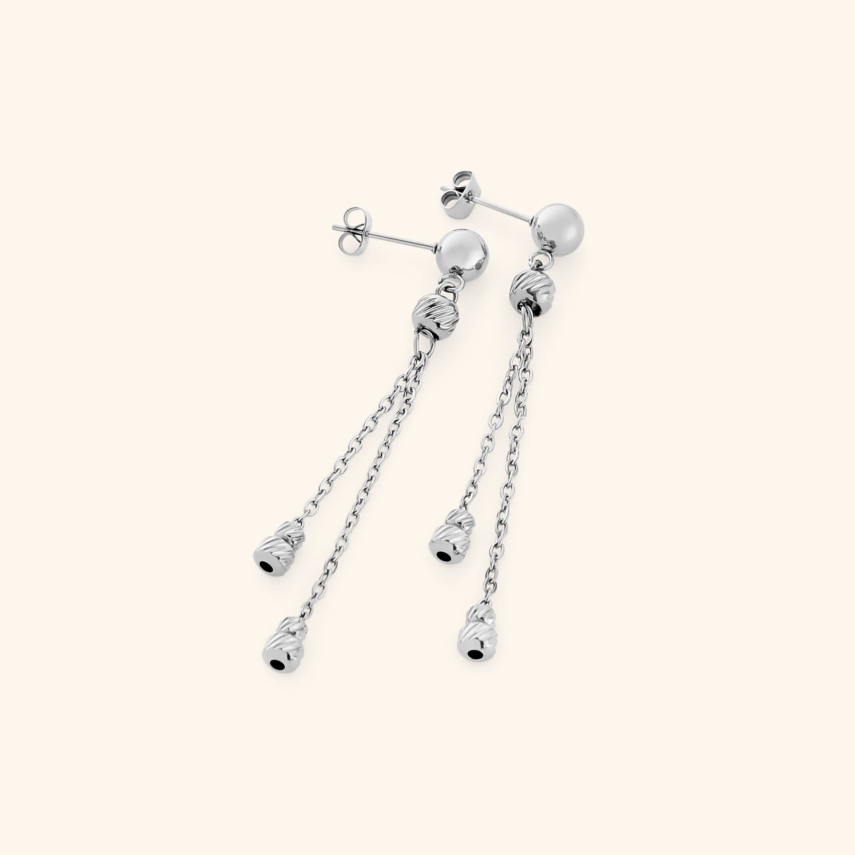 Pair of silver raining earrings featuring a polished stud with two slim chains, each ending in ribbed silver bead charms.
