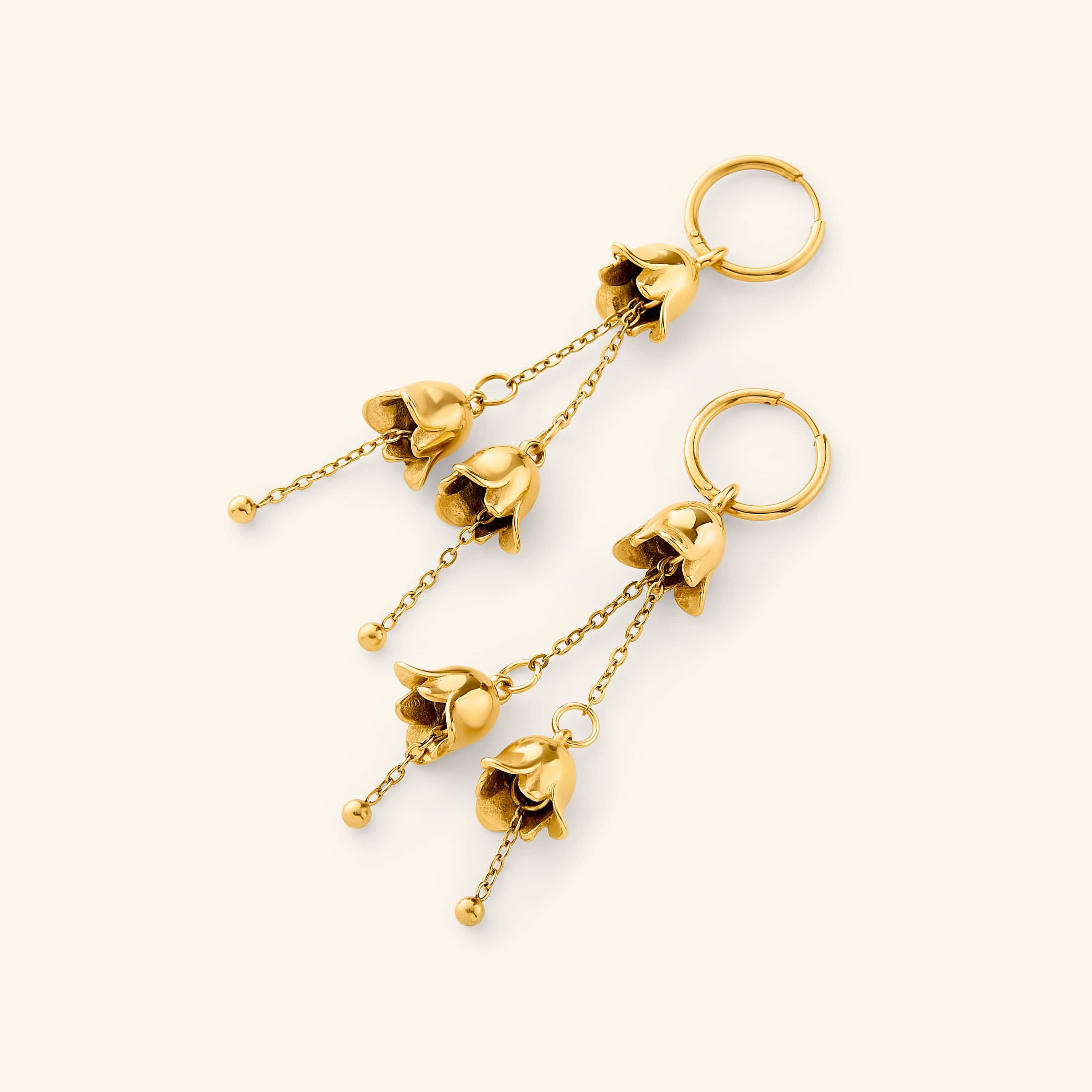 A pair of dangling Raining Tulip Hoops in gold, designed with delicate floral-inspired drops hanging from fine chains attached to small hoops.