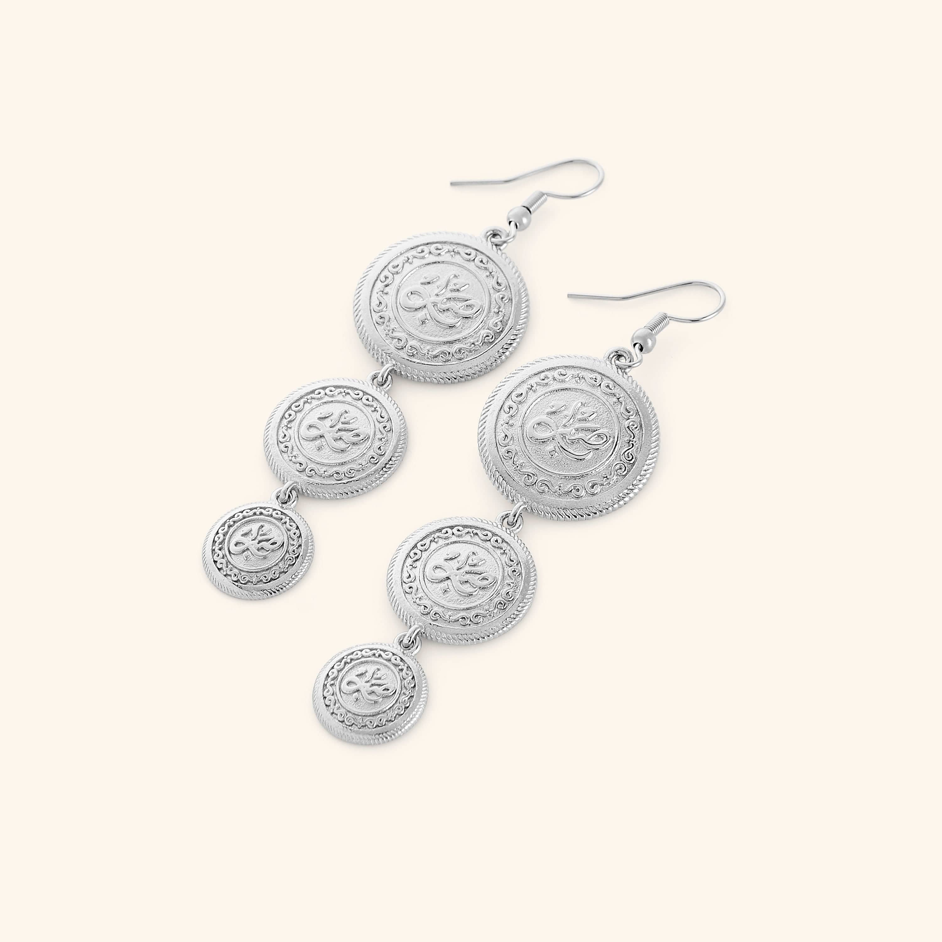 A pair of tri-coin silver plated earrings  embossed with Arabic calligraphy "Sabr". The coins drape from each other with a gold double-chain.