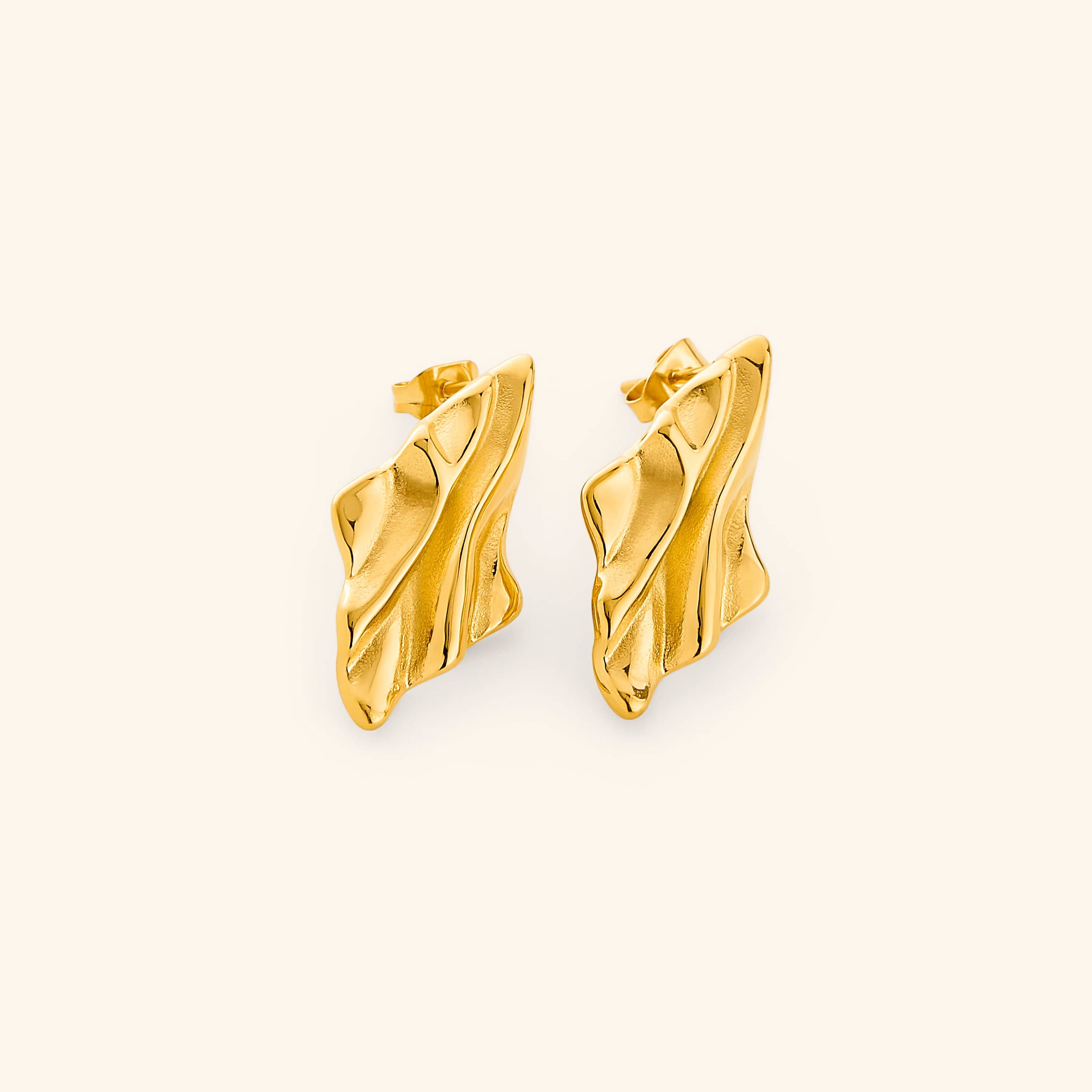 Gold earrings with a melted design appearance, on a white background