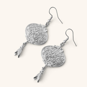 “Walk to Me, and I'll run to you” Medallion Earrings in silver, featuring engraved Arabic calligraphy and a small dangling charm.