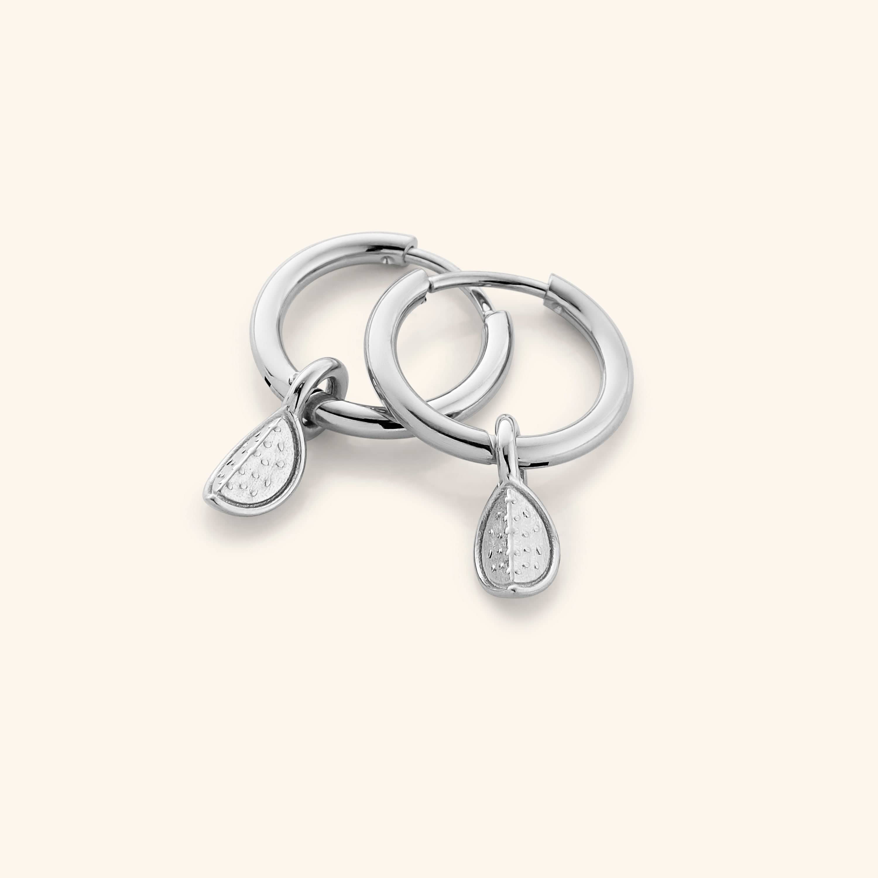 The Watermelon Hoops in a polished silver finish, showcasing the semi-circular watermelon slice design with red enamel, black seeds, and green rind detailing, representing the Palestinian flag colors.