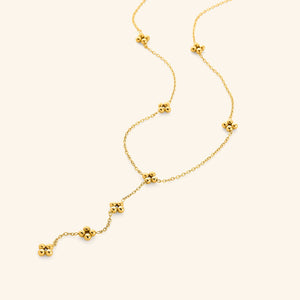 Close-up of the Henna Lariat Necklace in gold, featuring delicate chain links with small clustered bead accents and a drop lariat design.