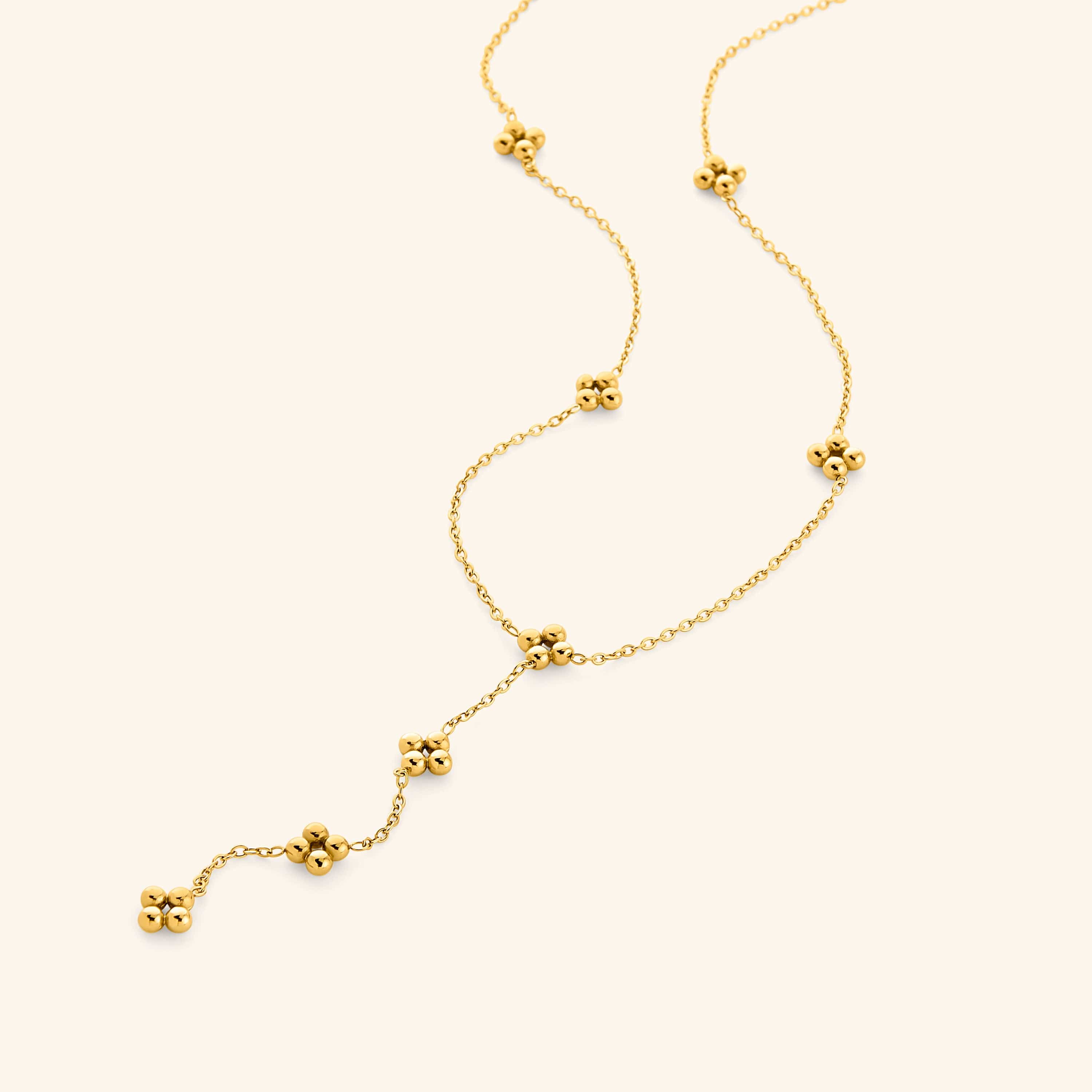 Close-up of the Henna Lariat Necklace in gold, featuring delicate chain links with small clustered bead accents and a drop lariat design.