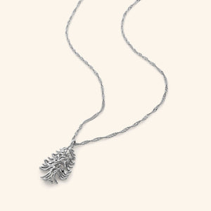 Silver necklace featuring the Arabic phrase "Freedom is the soul", swirled into the shape of the Cedar of Lebanon tree on a thin twisted gold chain.