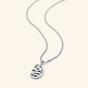 The My Sister Oval Necklace in a polished silver finish, showcasing the oval pendant engraved with "أختي" ("Ukhti" – My Sister) in graceful Arabic script, hanging from a sleek silver curb chain.
