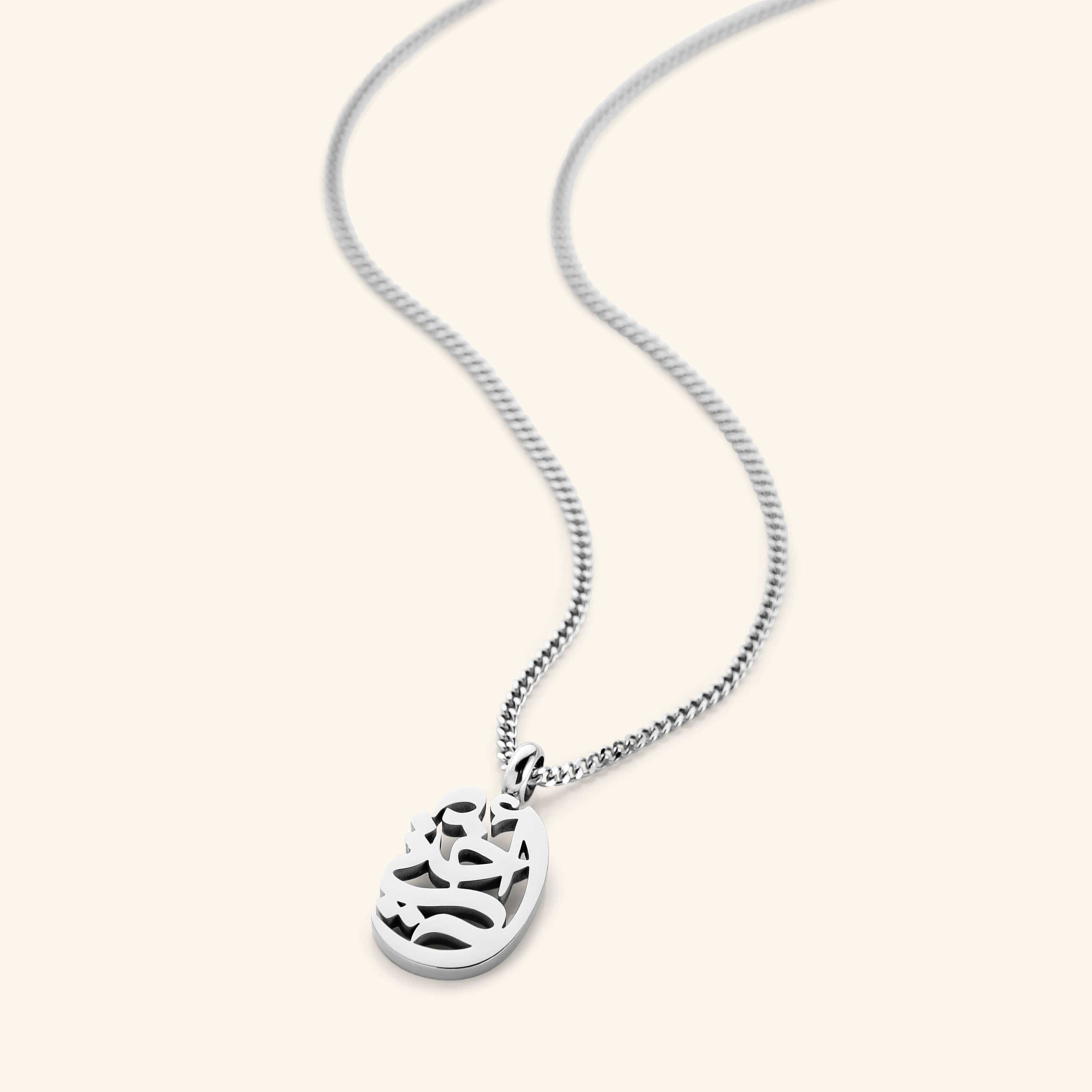 The My Sister Oval Necklace in a polished silver finish, showcasing the oval pendant engraved with "أختي" ("Ukhti" – My Sister) in graceful Arabic script, hanging from a sleek silver curb chain.