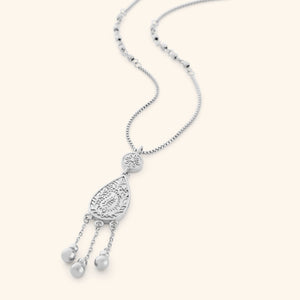 A silver necklace the features paisley droplet traced with mehndi-inspired florals, suspended from a beaded chain with three spheres hanging beneath like rain on a thin box chain.