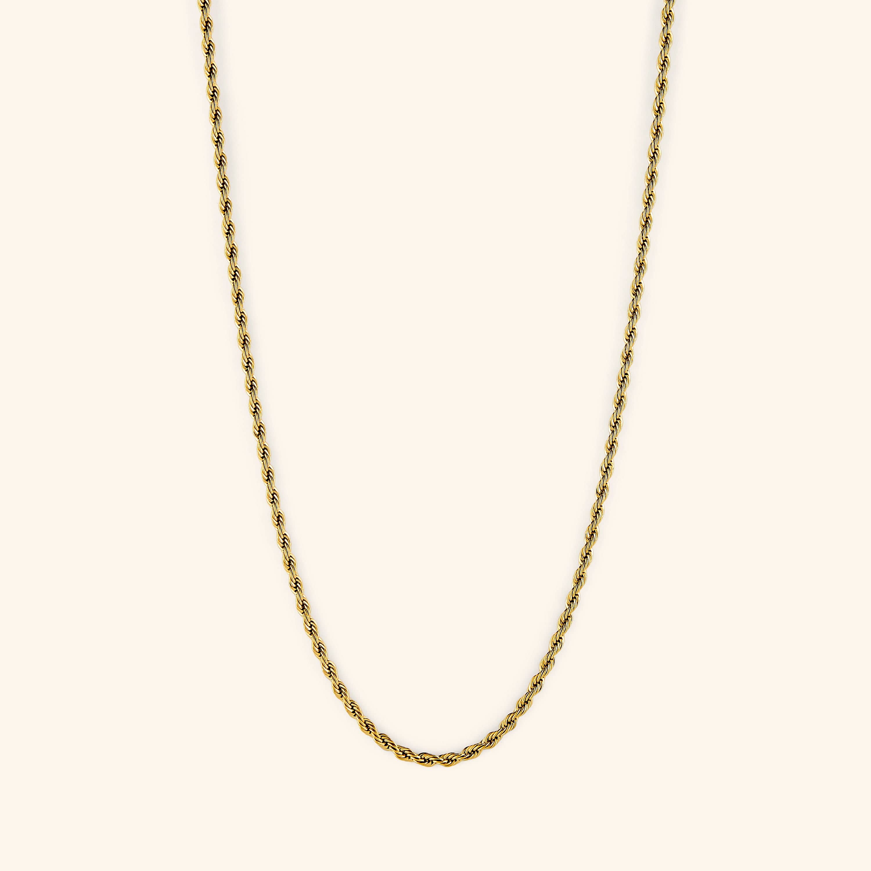 Gold rope chain necklace displayed on a light cream background