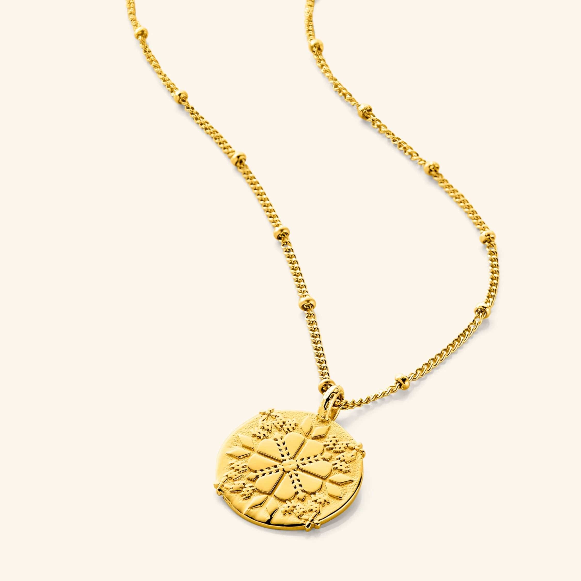 An 18k gold plated necklace with a round pendant that features design that is inspired by the centuries-old Palestinian embroidery attached on an 18k gold plated dotted chain.