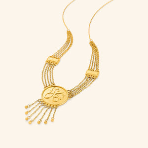 A gold necklace crafted from multiple chains and finished with a token inscribed with the Arabic word for 'trust'