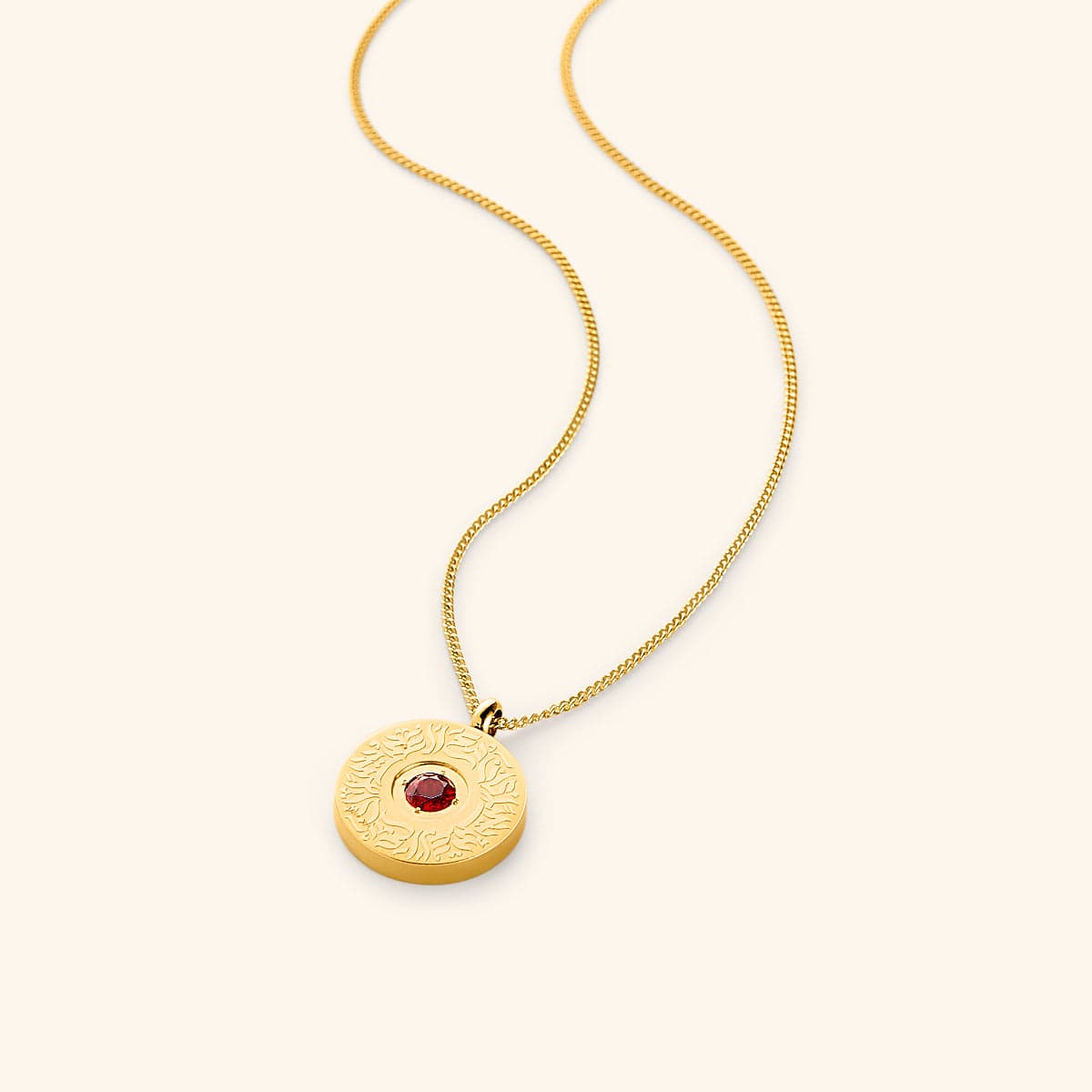 A round gold medallion pendant on a gold chain, featuring a red agate stone in the center surrounded by engraved Arabic calligraphy.