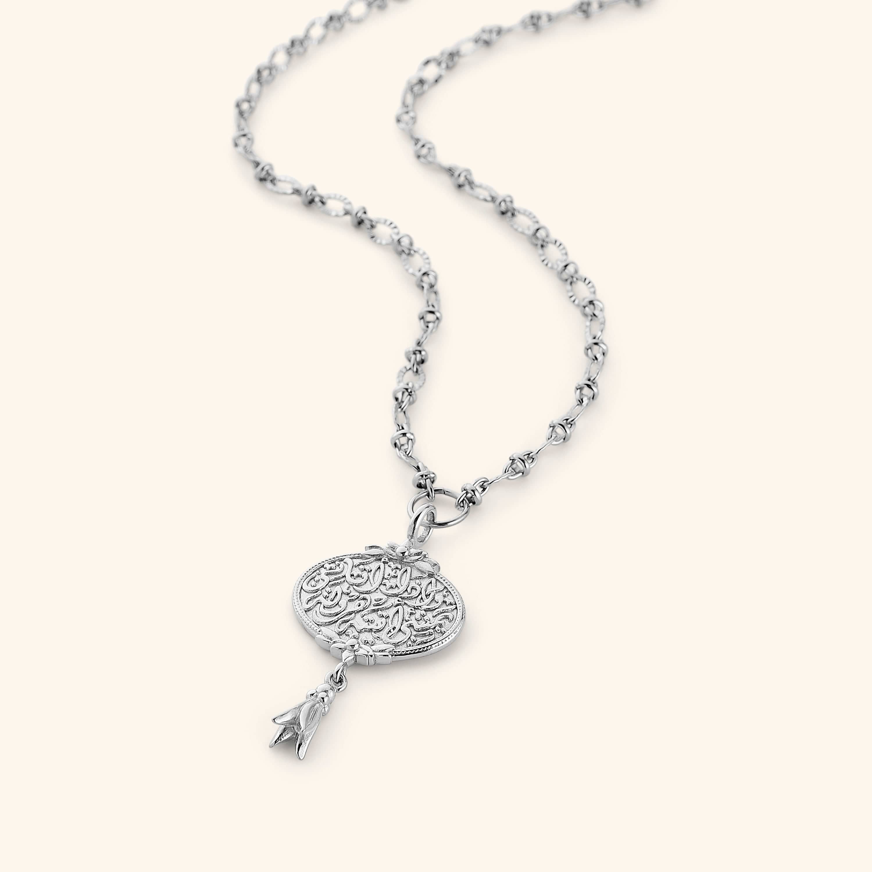 A medallion-shaped silver necklace carved with a line from Hadith Qudsi: "Walk to Me and I will run to you." This pendant is suspended with a unique chain that interconnects oval shaped ridged links.