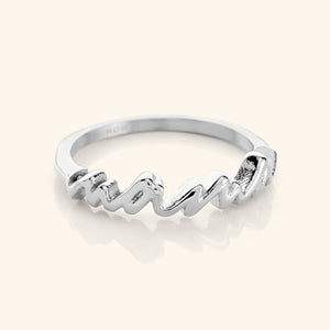 A close-up of the English Mama Ring in silver. The ring features the word "Mama" in cursive script.