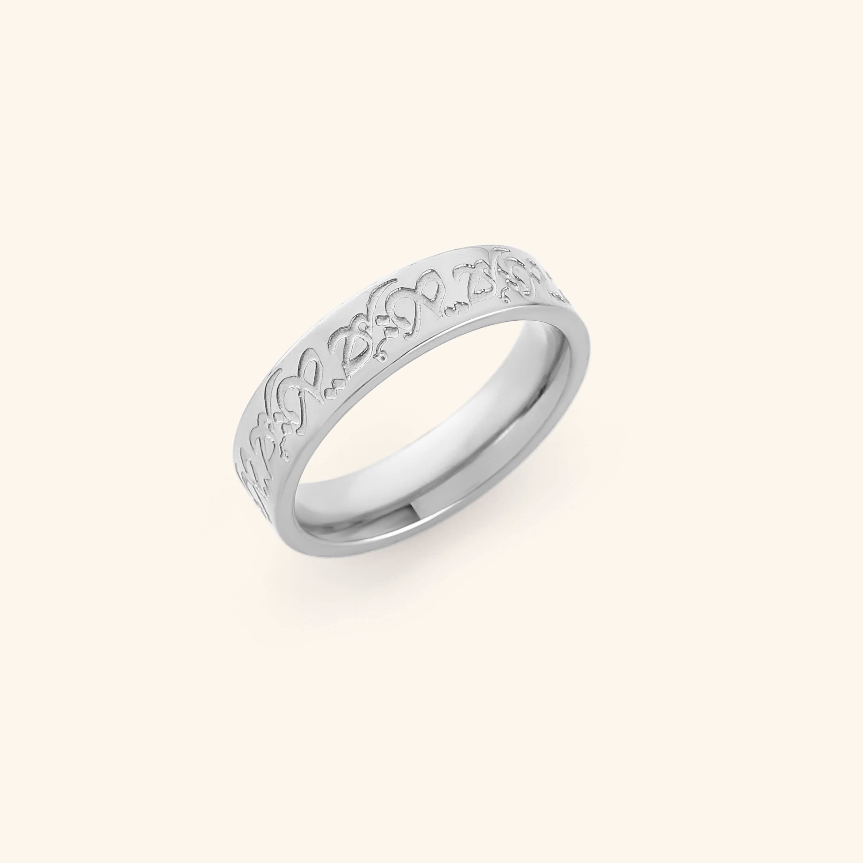 Silver Hurriya Freedom ring with intricate arabic calligraphy on a light background