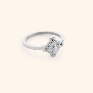 Silver kitework ring featuring a raised, textured centerpiece.