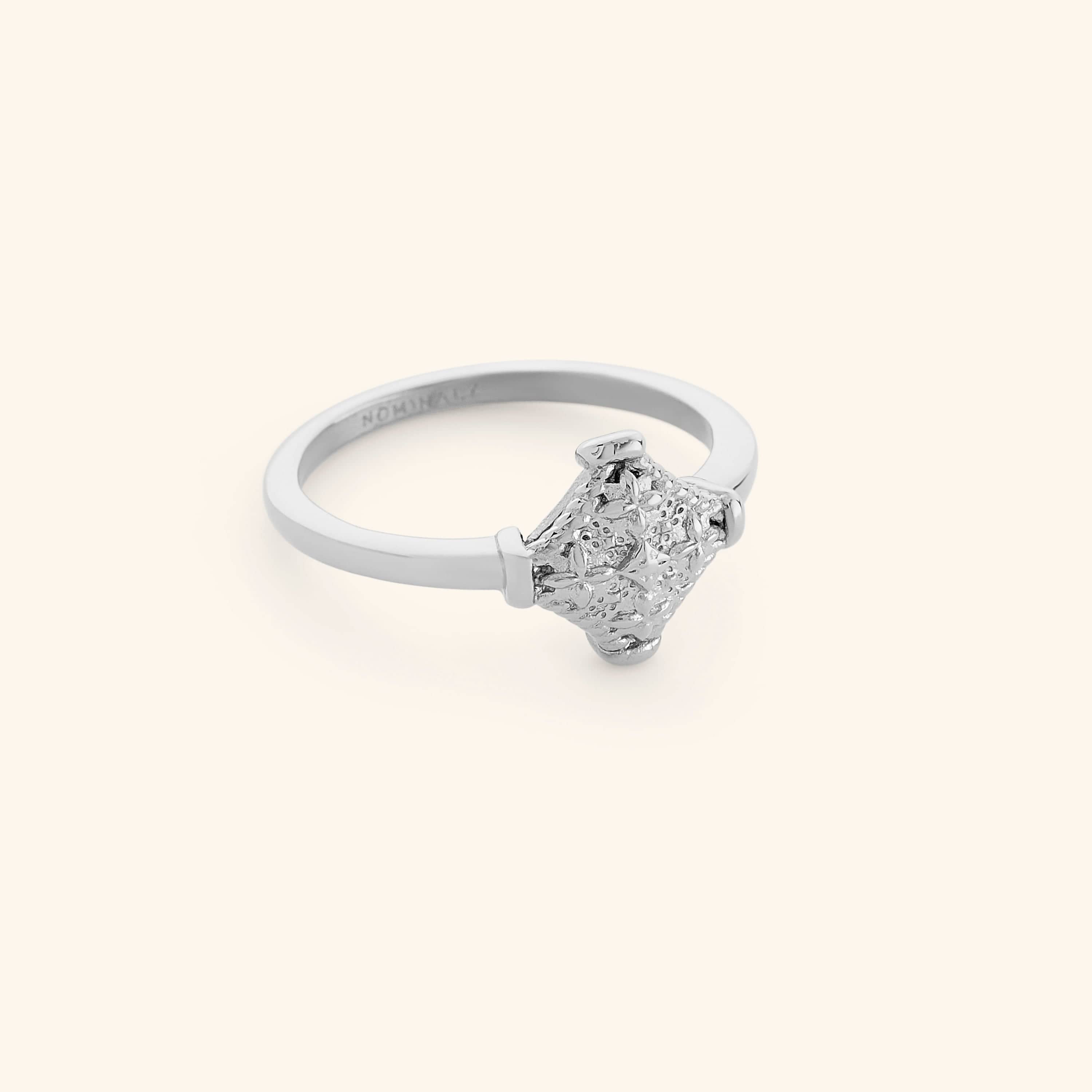 Silver kitework ring featuring a raised, textured centerpiece.