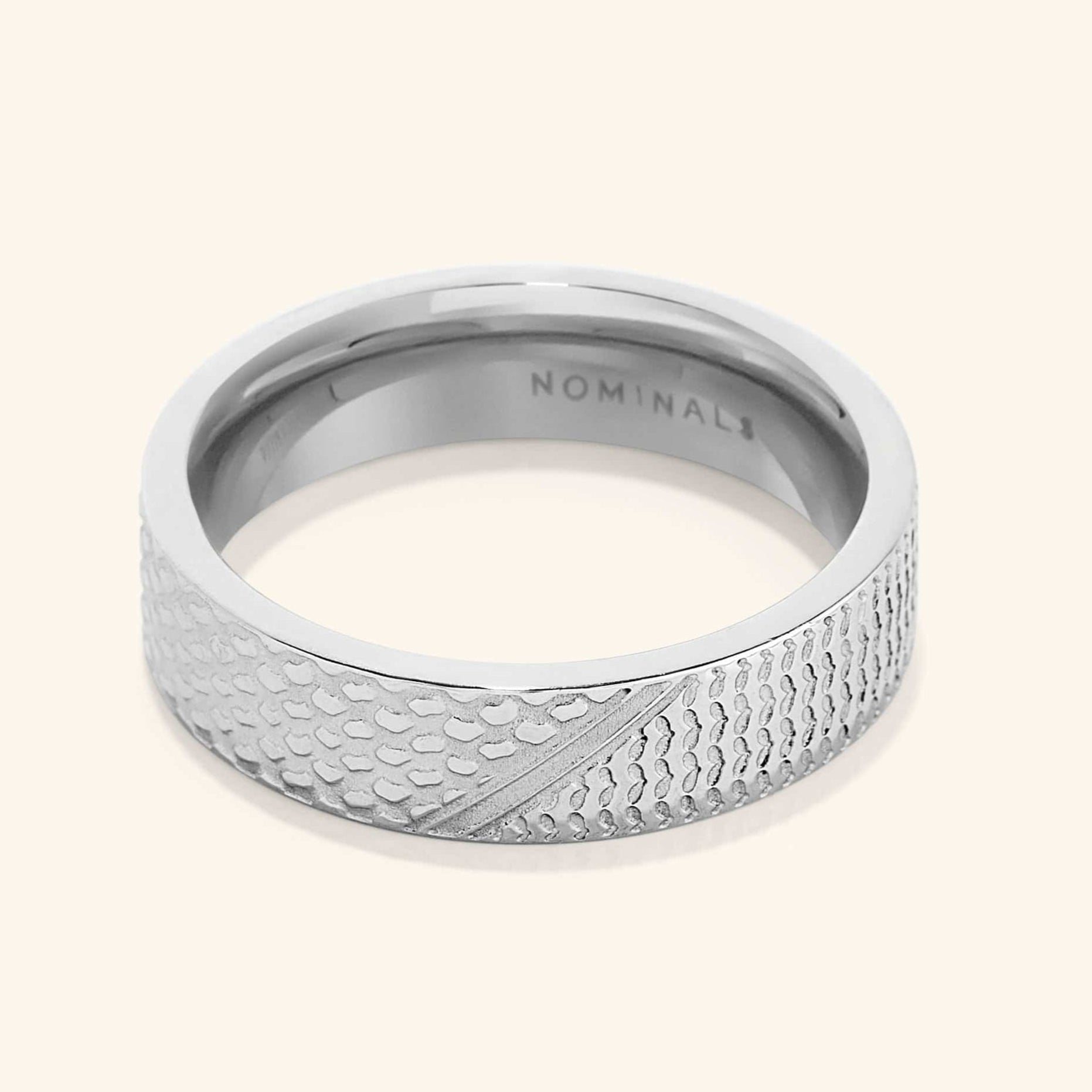 A close-up of the Keffiyeh Ring in silver, featuring intricate engravings inspired by the traditional Palestinian keffiyeh pattern, including fishnet designs, bold lines, and olive leaves.